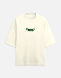 Cream oversized t-shirt with small green forest graphic on chest, minimalist style