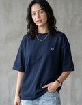 Woman wearing navy blue oversized t-shirt with small fox logo, light denim jeans, casual style
